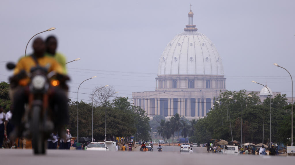 Aerial view of Yamoussoukro showcasing urban expansion and the iconic Notre Dame de la Paix Basilica.