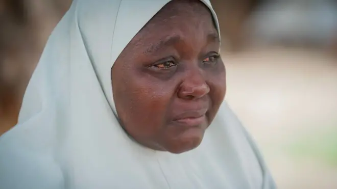 Une femme portant un hijab blanc, les yeux rouges d'avoir pleuré
